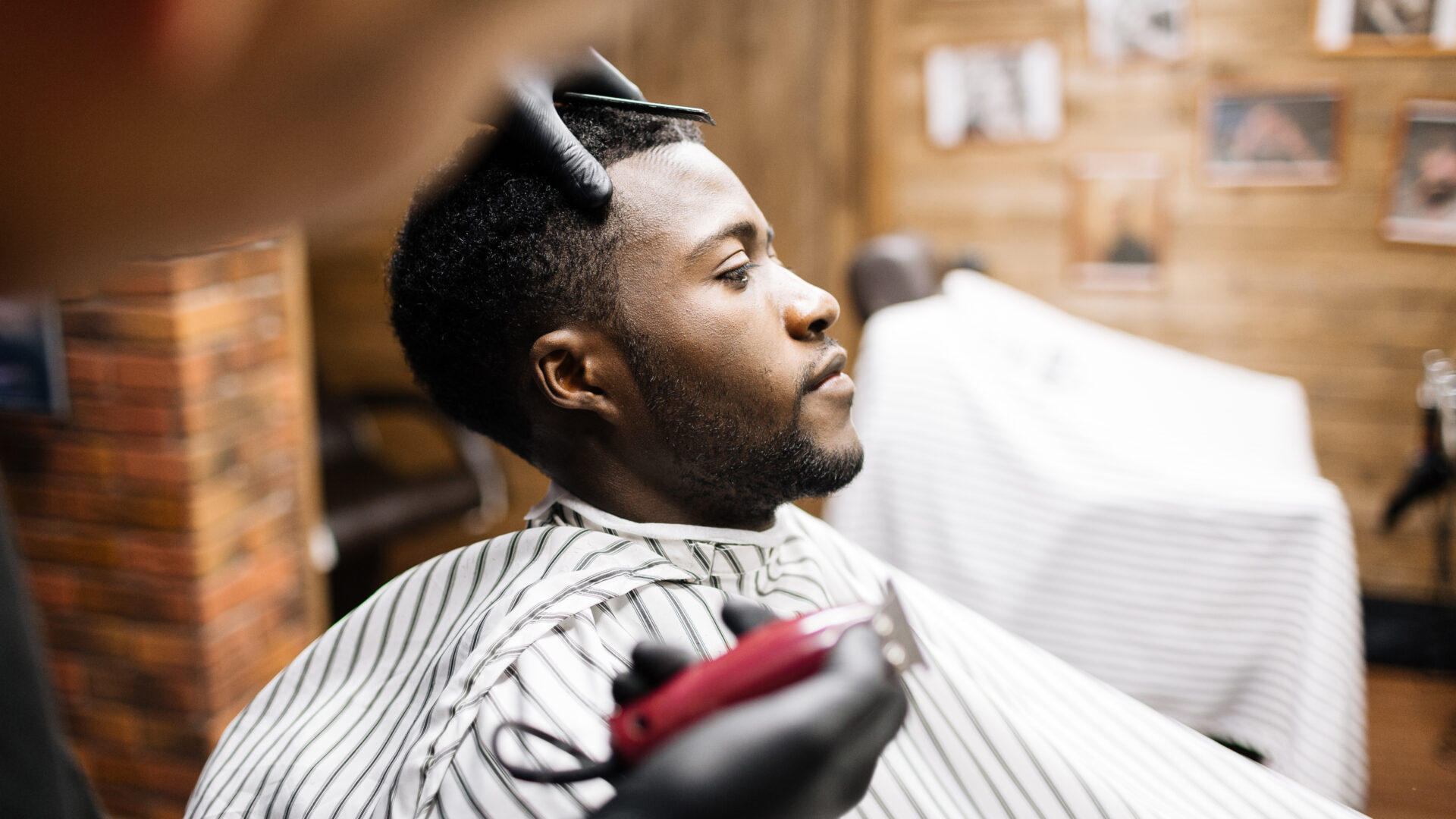 Man wrapped in napkin sitting in armchair in barbershop